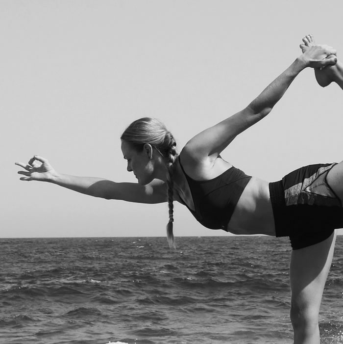 Imagen en blanco y negro de Marieke haciendo yoga al borde del mar